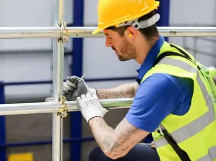Construction worker inspecting metal scaffolding