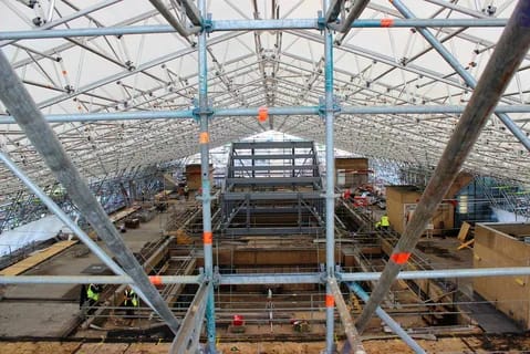 Interior view of large-scale industrial scaffolding structure supporting construction work